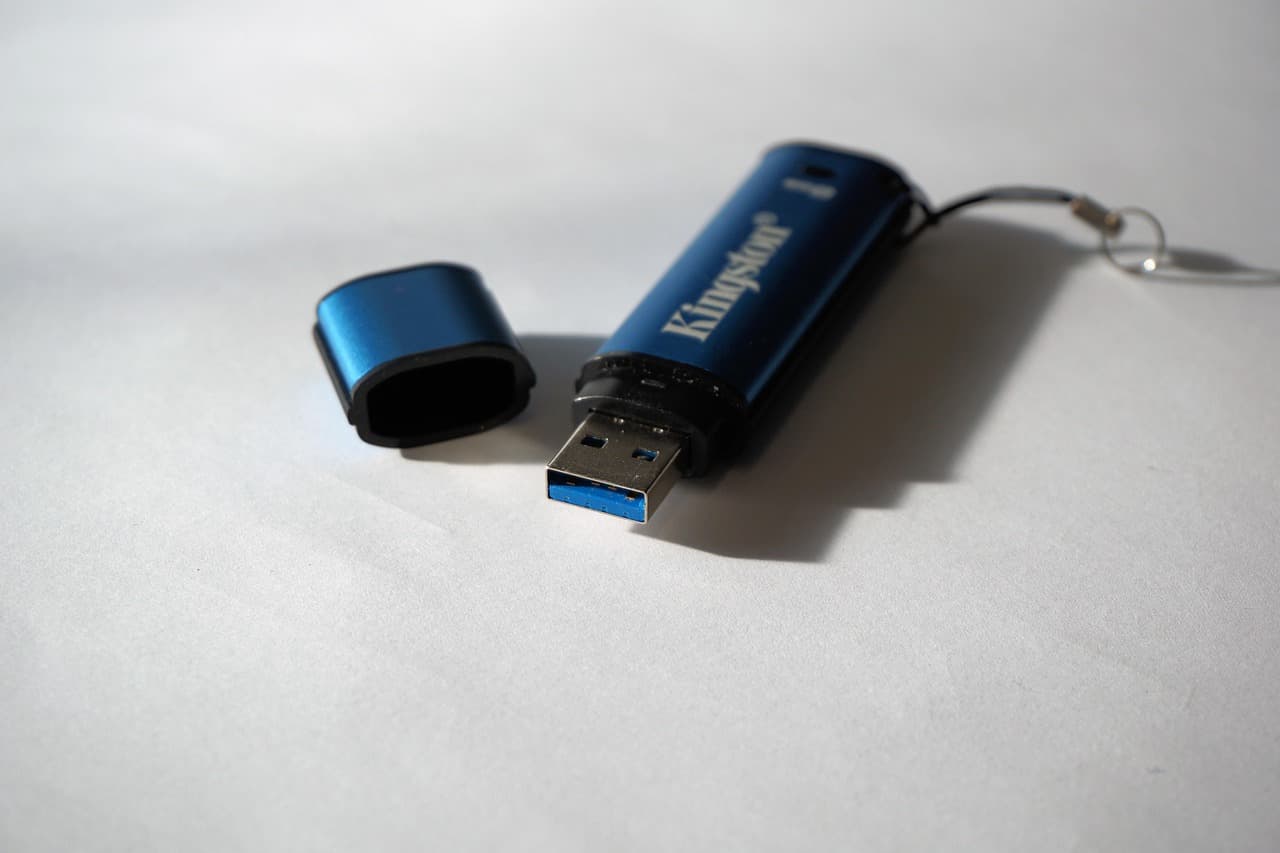 A USB flash drive on a desk next to a computer