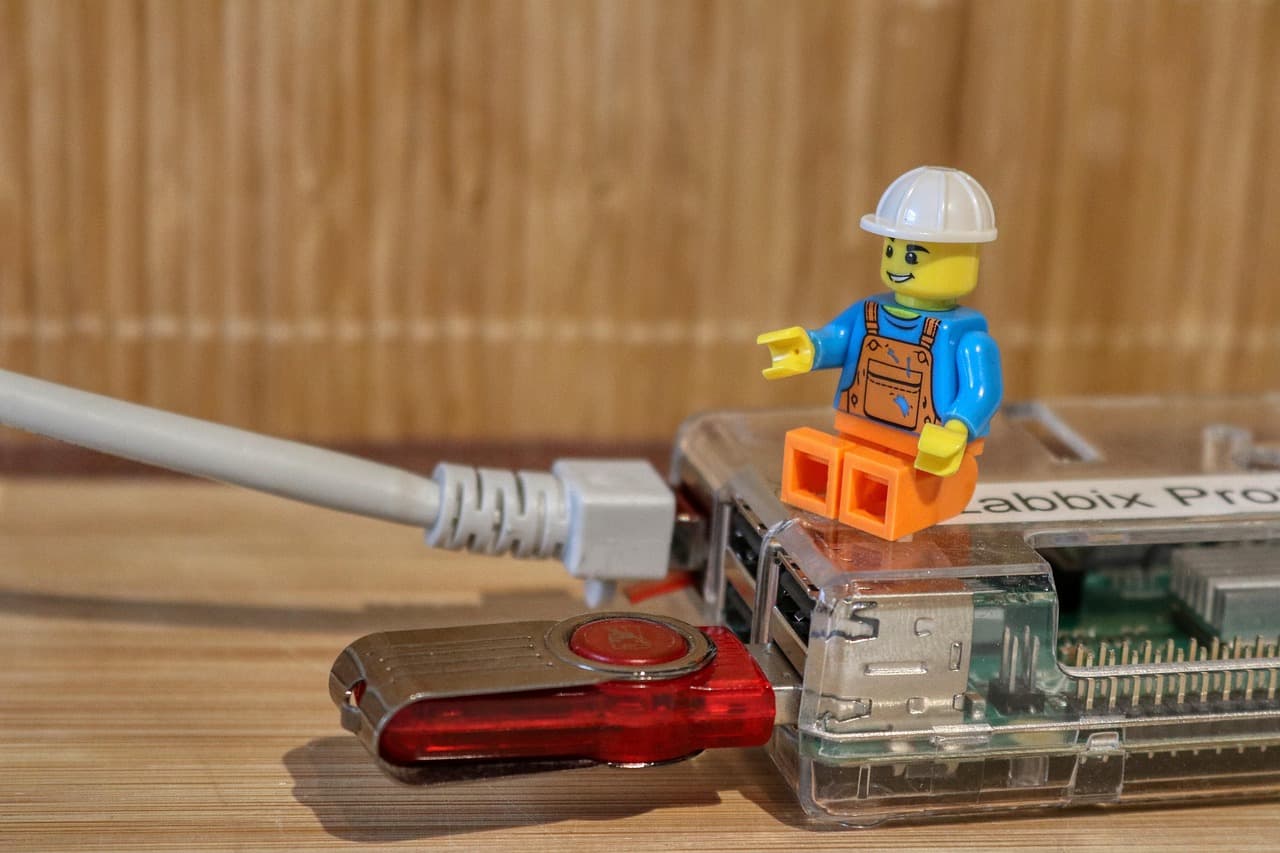 A USB flash drive being held next to a laptop
