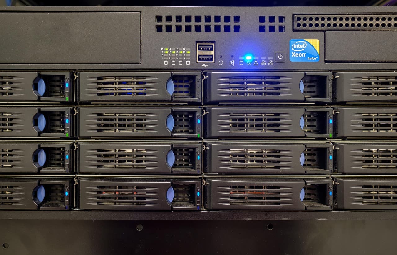 A frente de um servidor montado em rack, com quatro filas de baias de disco hot-swap e um indicador de estado azul aceso